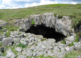 The arched gritstone entrance to Chartist Cave